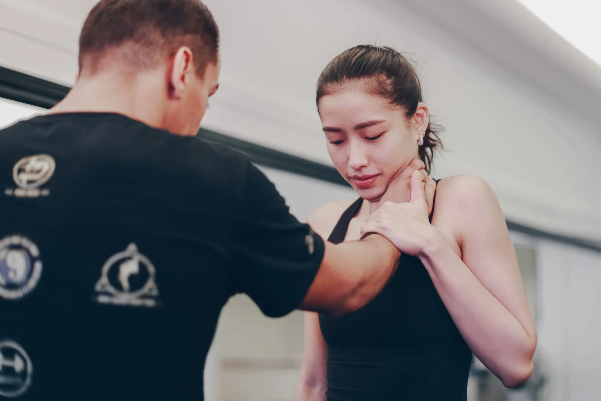 A JEET Academy KL coach teaching a student to escape a one-hand grab to the throat, at the studio in Bangsar, Kuala Lumpur